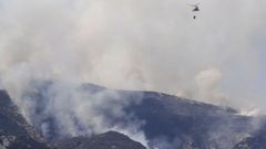 Un helicoptero trabaja en las labores de extinci�n del incendio forestal declarado en Belmonte. Asturias
