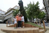 Una familia posa delante del Dinoseto, en la Porta do Sol, con un palo para realizar selfies. 