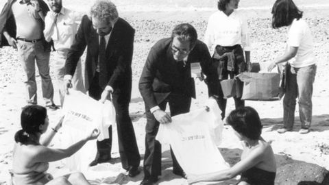 Javier Vidal repartiendo camisetas liberales, con Antonio Garrigues, en la playa de Ribadesella.