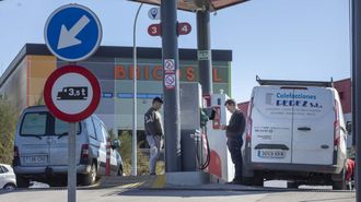 Dos trabajadores repostan sus furgonetas en una gasolinera de Santiago