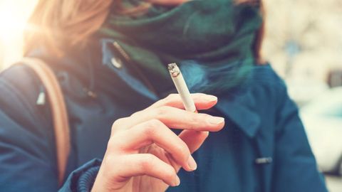 Imagen de archivo de una mujer joven fumando un cigarrillo