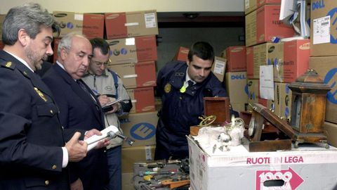 El delegado del Gobierno en Madrid, Francisco Javier Ansuategui, segundo por la izquierda en la imagen, observa en la comisar�a de Usera-Villaverde material incautado a los tres presuntos aluniceros  detenidos en la operaci�n Sanabria