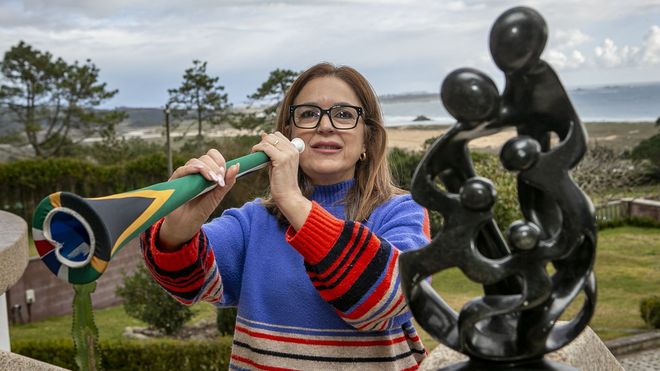 Juana Figueiras, con una vuvuzela y una figura que representa a la familia de Nelson Mandela