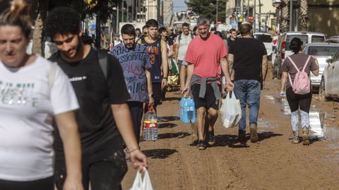 Varias llevan bolsas llenas comida tras los daos causados por la dana en sus viviendas