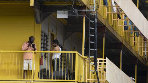 Dos hombres charlan en  el exterior de un edificio de confinamiento de Singapore