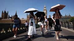 Varias personas se protegen del sol con paraguas en Londres