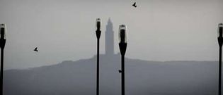 Varios p�jaros vuelan entre las farolas del Monte de San Pedro con la torre de H�rcules al fondo. 