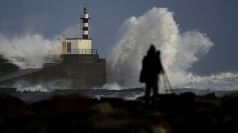 Un c�mara toma im�genes de las olas estrell�ndose contra el puerto de San Esteban de Pravia