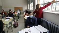 Una profesora abre las ventanas para ventilar un aula de secundaria