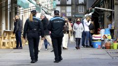 Una pareja de la Polica Local patrulla a pie el entorno de la plaza de abastos de Santiago