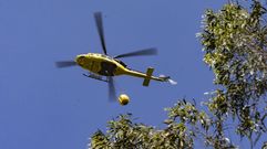 Un helic�ptero tratando de extinguir el fuego en Laxe, el domingo