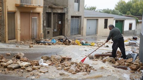 Un hombre recoge los escombros de una vivienda afectada por la dana