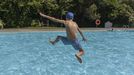 En foto de archivo, un joven se divierte saltando en una piscina.