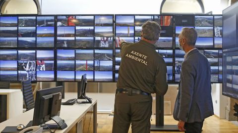 El agente ambiental Juan Carlos Sixto muestra al jefe provincial de Incendios de A Coru�a el lugar en el que se est� produciendo una quema controlada