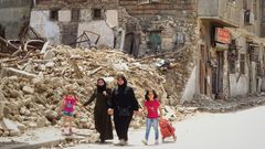 Dos mujeres caminan con dos nias ante los escombros de un edificio afectado por el terremoto que sacudi Turqua y Siria