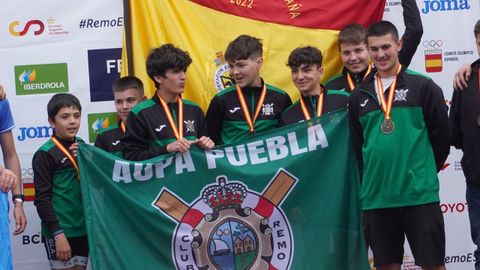 Los pobrenses, en el podio tras recoger las medallas y con la bandera de Espa�a que les acredita como campeones nacionales.