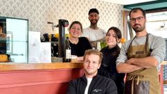 Áxel (sentado) y Miguel (con mandil) con parte del equipo de Corner, el hermano pequeño de Adèlia Café, abierto a solo 130 metros de allí, en la esquina entre la Algalia de Abaixo y la rúa dos Truques.