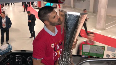 Fran Rico besa el trofeo de la Europa League en el autobs del Sevilla