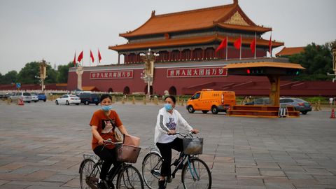 Personas andan en bicicleta por la Plaza Tiananmen luego de un brote de la enfermedad del coronavirus, durante la hora pico de la maana en Beijing, China
