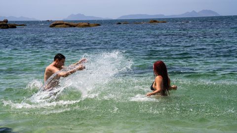 Una pareja disfrutaba ayer del agua con las islas C�es de fondo.