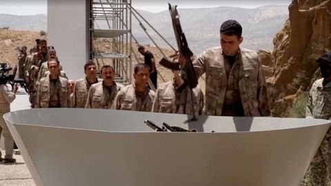 Combatientes del PKK depositan sus fusiles para ser quemados en un punto de la frontera de Turquía con Irak