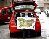 Baltar, no seu Volkswagen Golf vermello, cun mapa da provincia editado pola Deputaci�n.