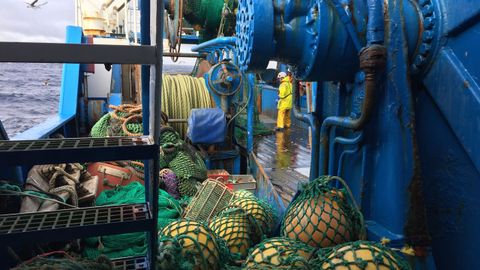 Vista parcial de la cubierta de popa de un arrastrero gallego, con boyas y un tripulante cerca de la rampa (foto de archivo).
