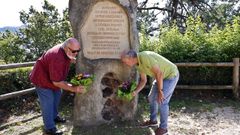 Paco y Eduardo Niebla dejan flores frente al monolito que recuerda a sus abuelos en A Gua, ngela Iglesias y Jos Niebla.