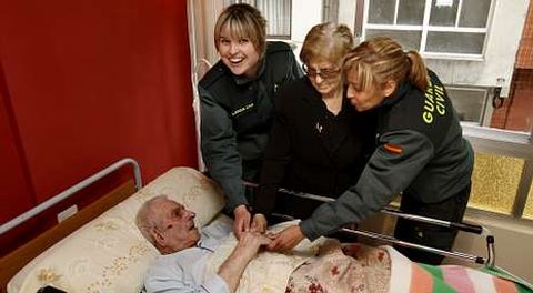 Las agentes María Janeiro (derecha) y Sandra Becerra estuvieron ayer con Lucía García, de 88 años, y José Francisco Castro, de 94.