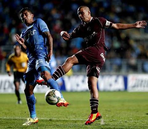 El Tucu defendiendo a Maximiliano Vel�zquer (Lan�s), en la Copa Libertadores. 