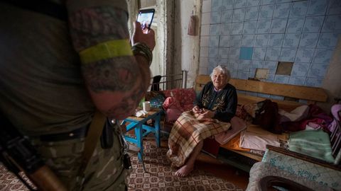 Un polic�a  toma im�genes en el interior de una vivienda durante una evacuaci�n en la localidad de Antonivka, en la provincia de Donetsk