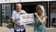Los propietarios de la cafetería Dayshe, Sergio González y Victoria Vispo, posan con el cartel del primer premio de la Bonoloto que se selló en su establecimiento.