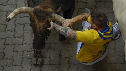 Momento en el que uno de los mozos es alcanzado por un toro