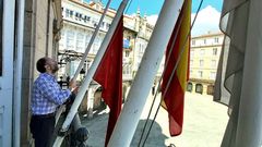 El alcalde, colocando las banderas a media asta