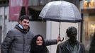 Unos turistas se fotograf�an bajo la lluvia y junto a la escultura de Woody Allen de Oviedo