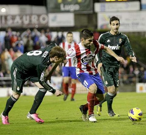 El capit�n Manu, tratando e controlar el bal�n entre dos jugadores del Castilla.