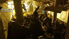 Un agente de la Guardia Civil comprueba los materiales de la plantaci�n de marihuana instalada en la casa de Gondomar.