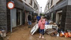 Una mujer junto a sus pertenencias embarradas en Els Poblets.
