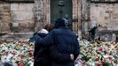 Dos personas observan las flores depositadas ante la iglesia de St. John's en Magdeburgo en honor de las v�ctimas del atropello masivo en el mercadillo navide�o de la ciudad