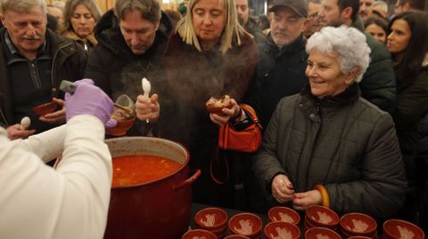 Una mujer espera su turno en el reparto de raciones de caldo de este domingo