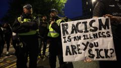 La polica observa a un manifestante antirracista que sostiene una pancarta en Walthamstow, al este de Londres, Gran Bretaa.