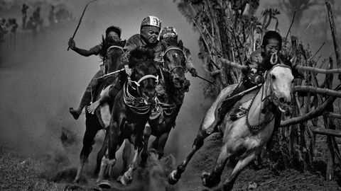 Fotograf�a cedida por la organizaci�n World Press Photo, que muestra la imagen captada por el fot�grafo Alain Schroeder, ganador del 1er premio de la categor�a �Sports - Stories�. La foto muestra a j�venes jinetes que compiten en una carrera de caballos de Maen Jaran, en la isla de Sumbawa, Indonesia, el 17 de septiembre del 2017.