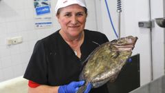 Rosa con un sanmarti�o, en su pescader�a de la avenida de Castelao, en Cedeira