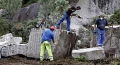 Trabajadores de Graexcon pican los bloques de granito para cargarlos en camiones y retirarlos. 