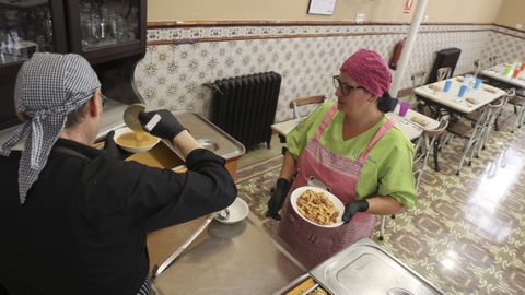 Ftima, empleada del comedor social, y Jose, trabajador del cterin Ferrolterra, emplatando los mens del medioda este mircoles en la Cocina Econmica