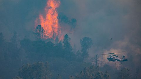 Un helicóptero vuela cerca de las llamas en el condado de Napa, California.