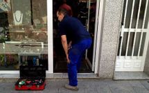 Un cerrajero instala una cerradura nueva en uno de los negocios afectados por los robos del 2010