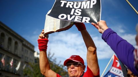 Un manifestante contrio al presidente impone el lema Trump se ha acabado a un contramanifestante en Washington