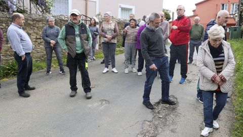 Los residentes recorren la carretera llena de baches que llega a sus casas. 
