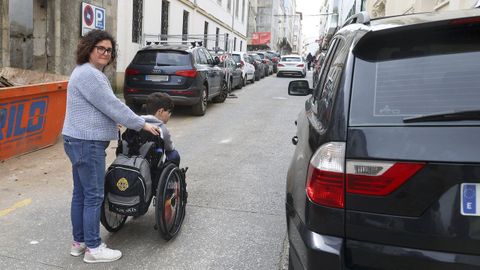 Mar�a con su hijo Jaime, por la calle del Sol entre coches sobre la acera derecha.